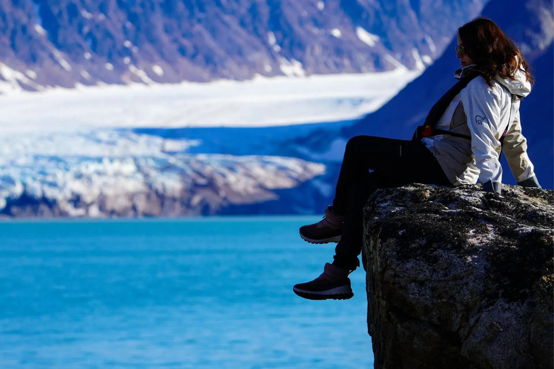 Giulia sitting on a rock in a Nordic landscape